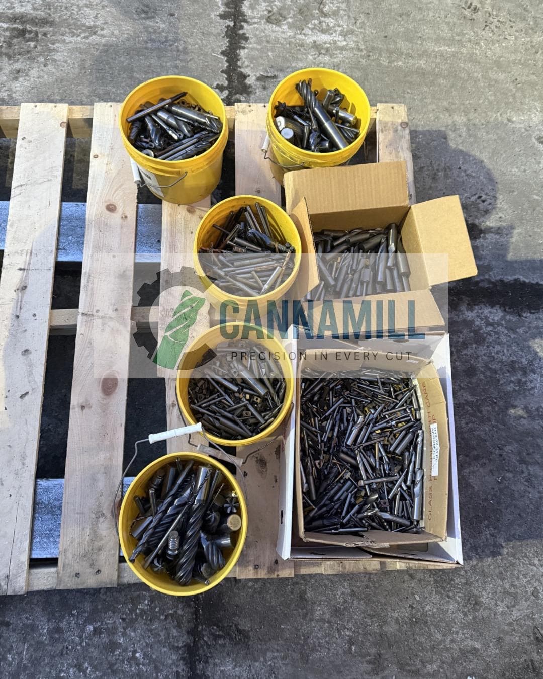Industrial scrap tungsten carbide tooling showing worn drills, end mills, and indexable inserts